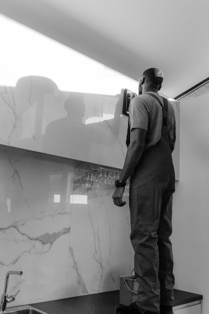 our-story A person professionally cleaning a glass surface in a stylish home interior.